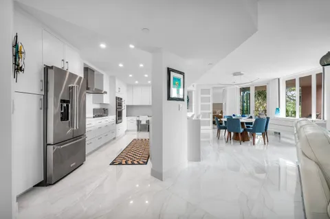 a kitchen with stainless steel appliances refrigerator dining table and chairs