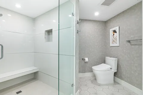 a bathroom with a toilet and a shower
