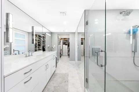a bathroom with a double vanity sink mirror and shower