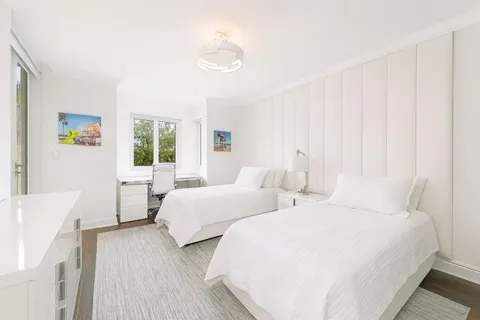 a bedroom with two beds and a large window