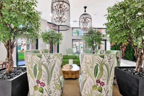 a living room with furniture a chandelier and a large mirror