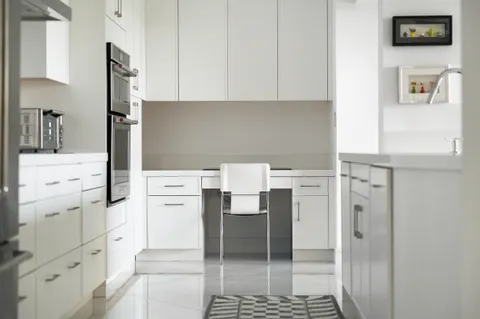 a kitchen with white cabinets and white appliances