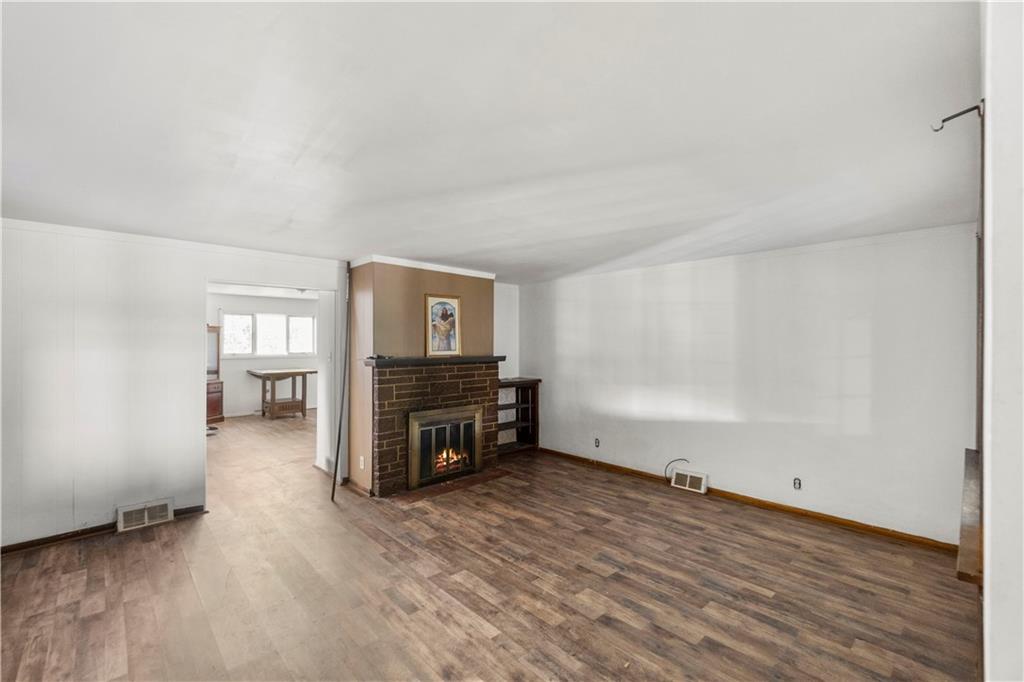 311 East Lutton Street New Castle, PA 16101 - Photo 7 of 10 an empty room with wooden floor and a fireplace