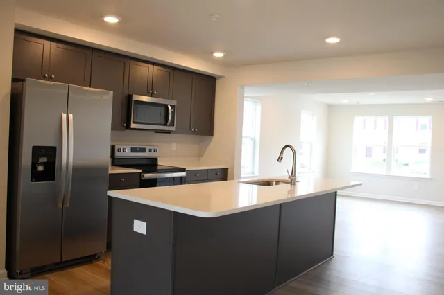a kitchen with kitchen island a sink stainless steel appliances and a window