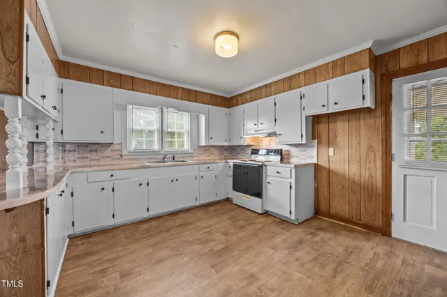 a kitchen with white cabinets sink and stainless steel appliances