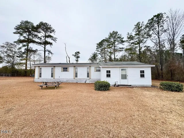 a view of a house with a patio and a yard