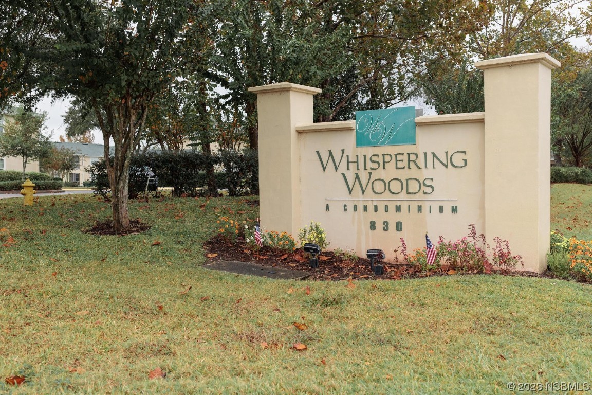a sign board with yard and trees