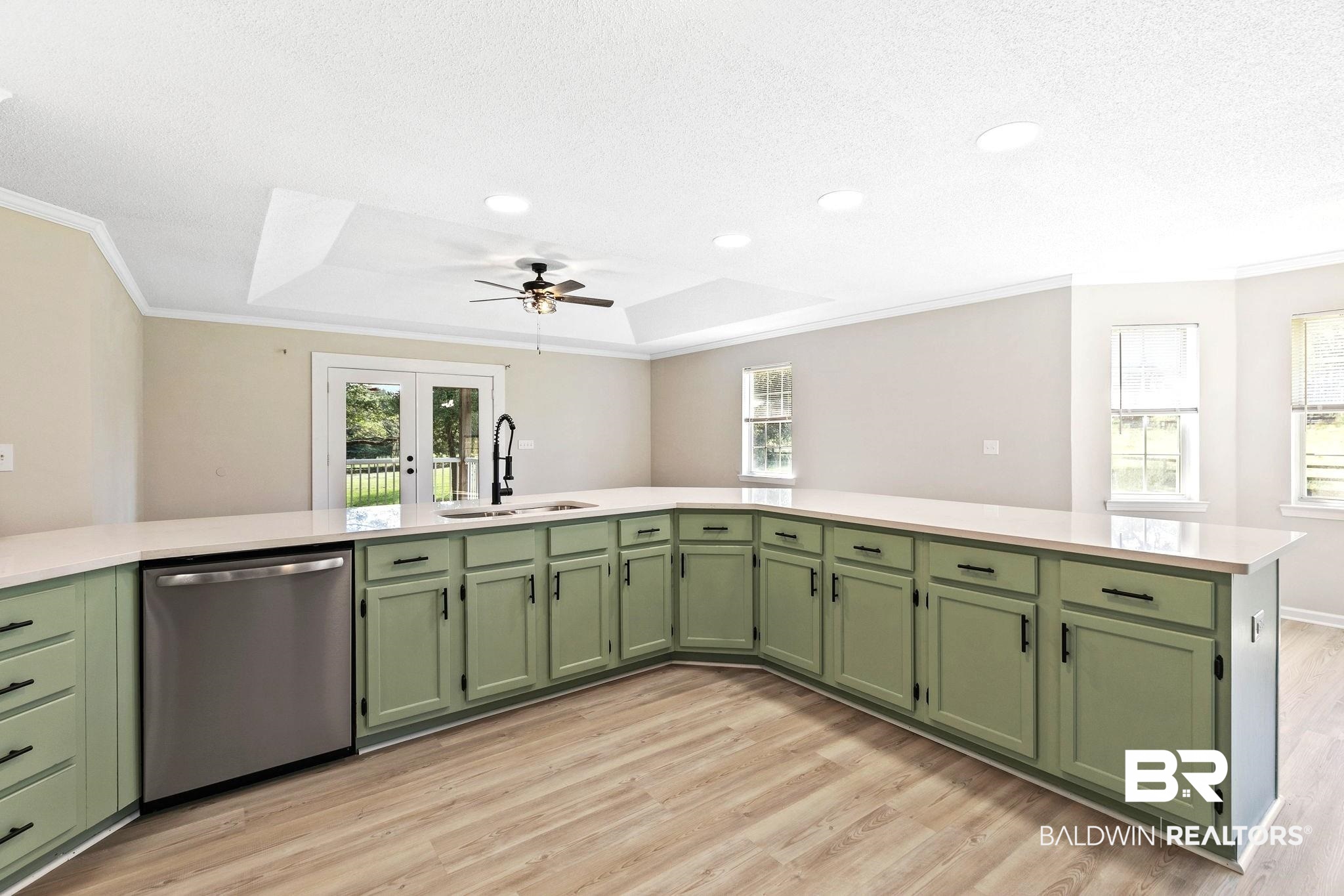 35650 Spring Road North Stapleton, AL 36578 - Photo 15 of 70 Kitchen featuring green cabinetry, a raised ceiling, stainless steel dishwasher, light wood-type flooring, and ornamental molding