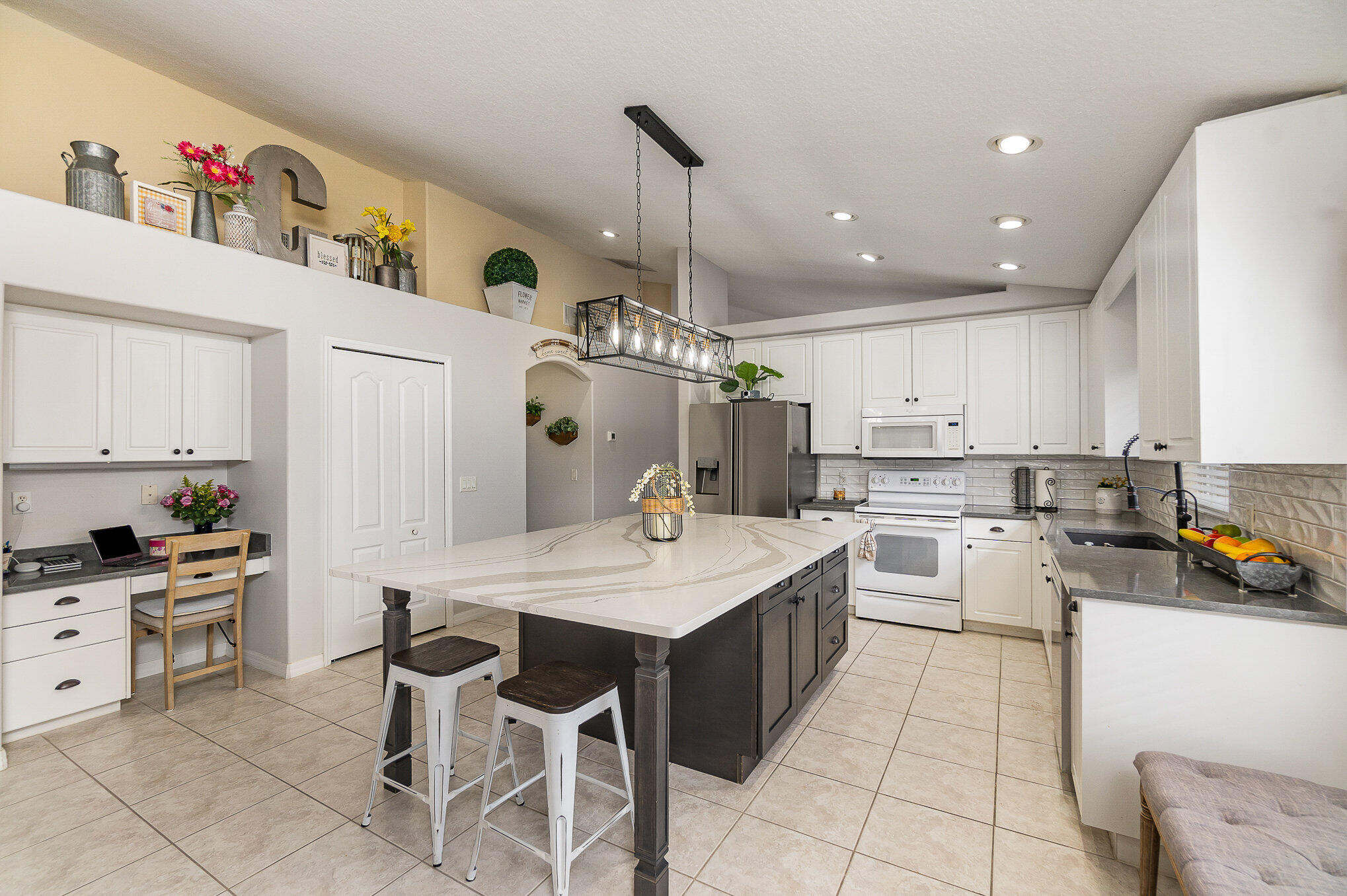 6914 Renshaw Drive Melbourne, FL 32940 - Photo 7 of 27 a kitchen with a white center island and cabinets