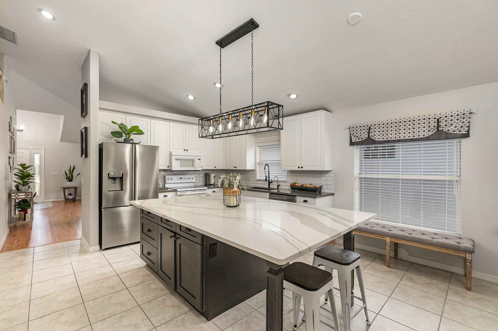 6914 Renshaw Drive Melbourne, FL 32940 - Photo 9 of 27 a kitchen with stainless steel appliances granite countertop a sink a stove and a refrigerator