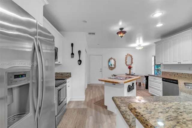 a kitchen with stainless steel appliances granite countertop a sink and cabinets