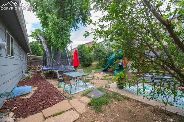 a backyard of a house with barbeque oven table and chairs