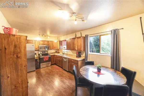 a kitchen with sink a refrigerator and chairs