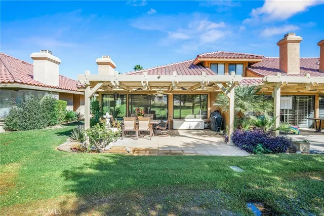a view of a house with backyard sitting area and garden