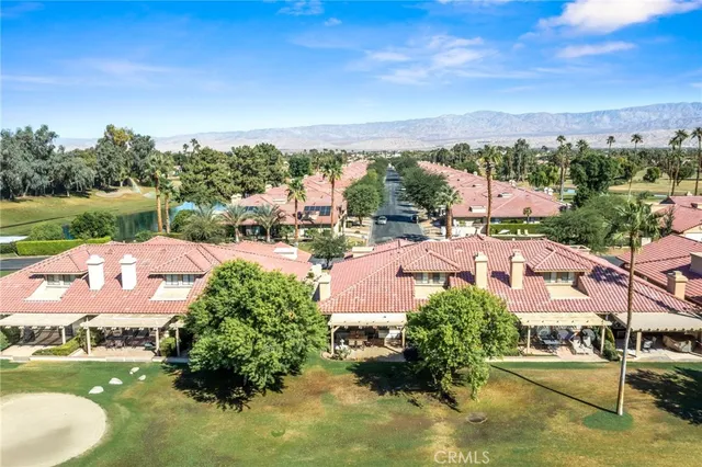 an aerial view of residential houses with outdoor space and trees
