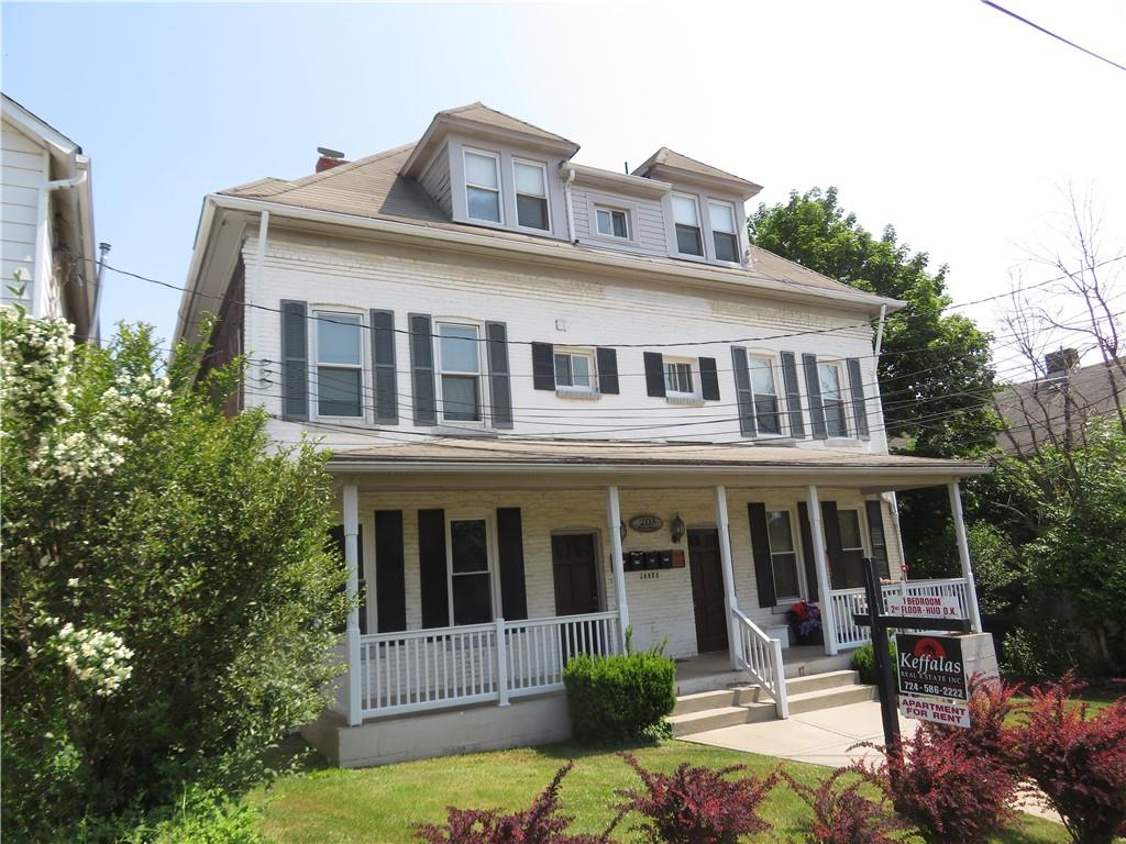 a front view of a house with garden and porch