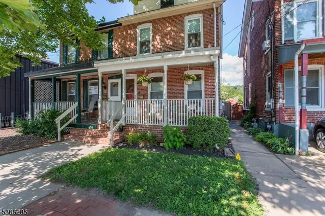 a view of a house with brick walls and a yard with plants