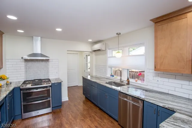 a kitchen with stainless steel appliances granite countertop a refrigerator and a stove top oven