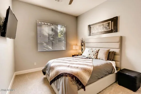 a bedroom with a bed a mirror and a window