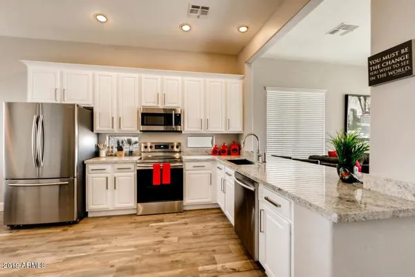 a kitchen with granite countertop a refrigerator and a sink