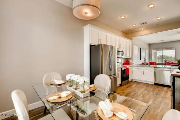 a kitchen with stainless steel appliances a refrigerator and dining table