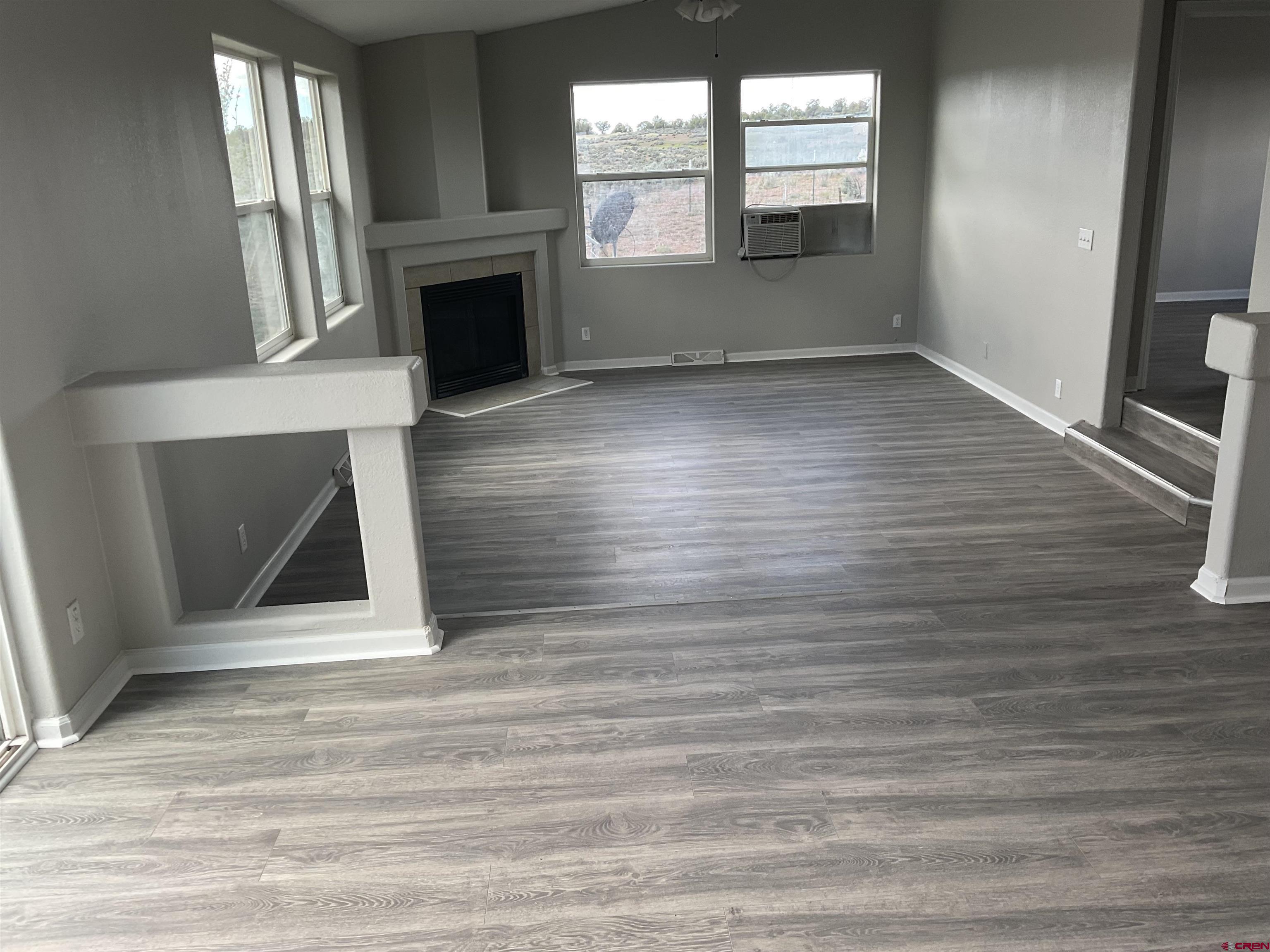 428 County Road 314 Ignacio, CO 81137 - Photo 10 of 24 an empty room with wooden floor fireplace and windows