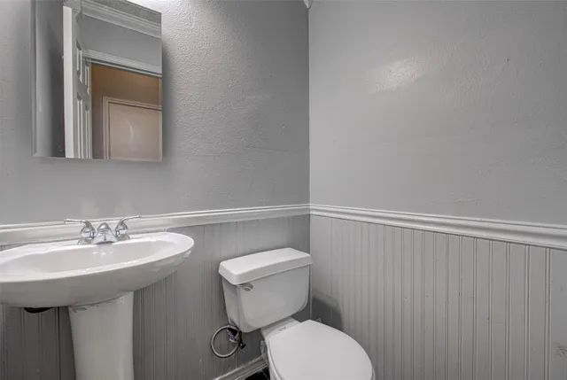 a bathroom with a toilet a sink and mirror