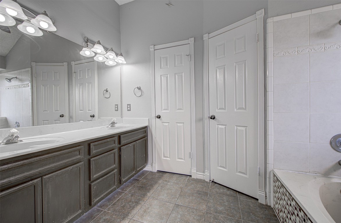 1401 Deepwoods Trail Leander, TX 78641 - Photo 17 of 34 a spacious bathroom with a double vanity sink a large mirror and a bathtub