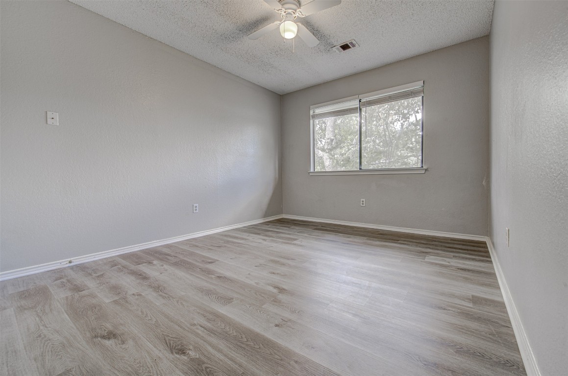 1401 Deepwoods Trail Leander, TX 78641 - Photo 26 of 34 an empty room with wooden floor and windows