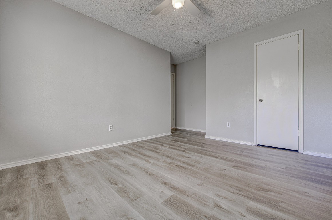 1401 Deepwoods Trail Leander, TX 78641 - Photo 27 of 34 a view of an empty room with wooden floor and a ceiling fan