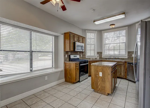 a kitchen with a refrigerator and a stove top oven
