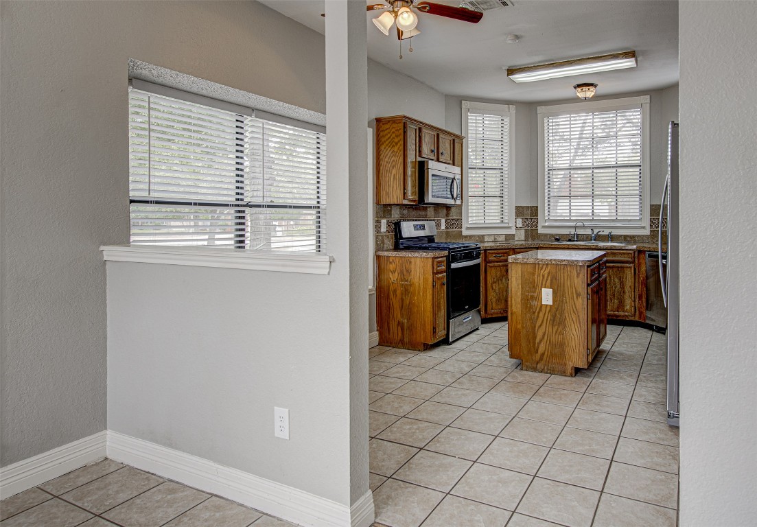 1401 Deepwoods Trail Leander, TX 78641 - Photo 5 of 34 a kitchen with granite countertop a stove a sink dishwasher and a refrigerator