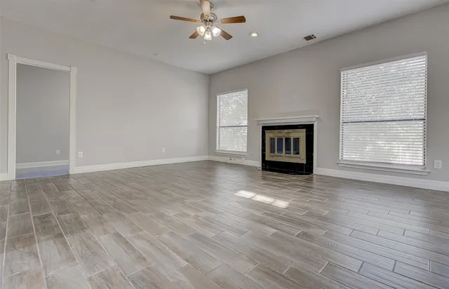 a view of an empty room with a window and fireplace