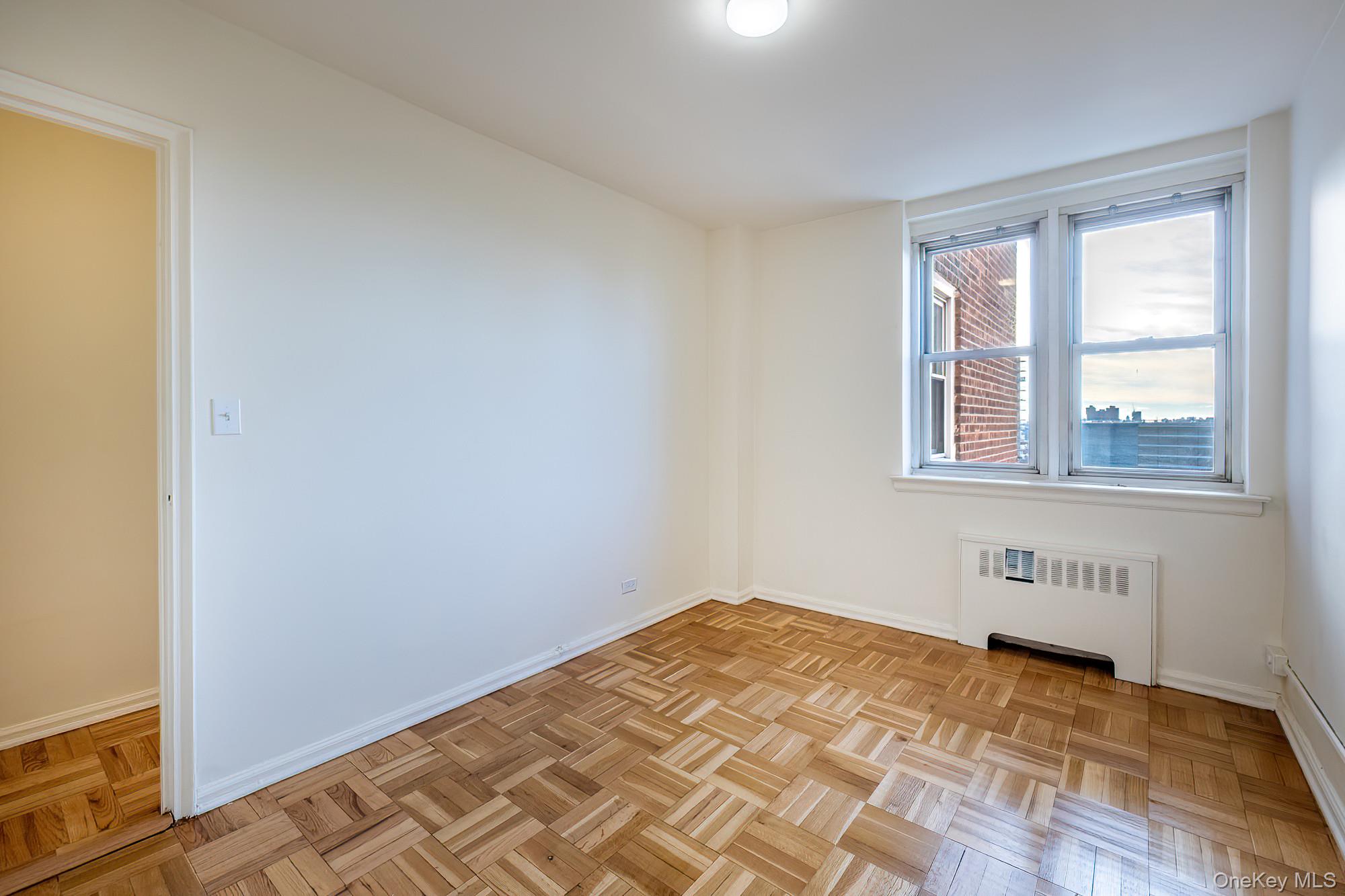 25 Knolls Crescent, Unit 8L Bronx, NY 10463 - Photo 11 of 21 Unfurnished room featuring radiator and baseboards