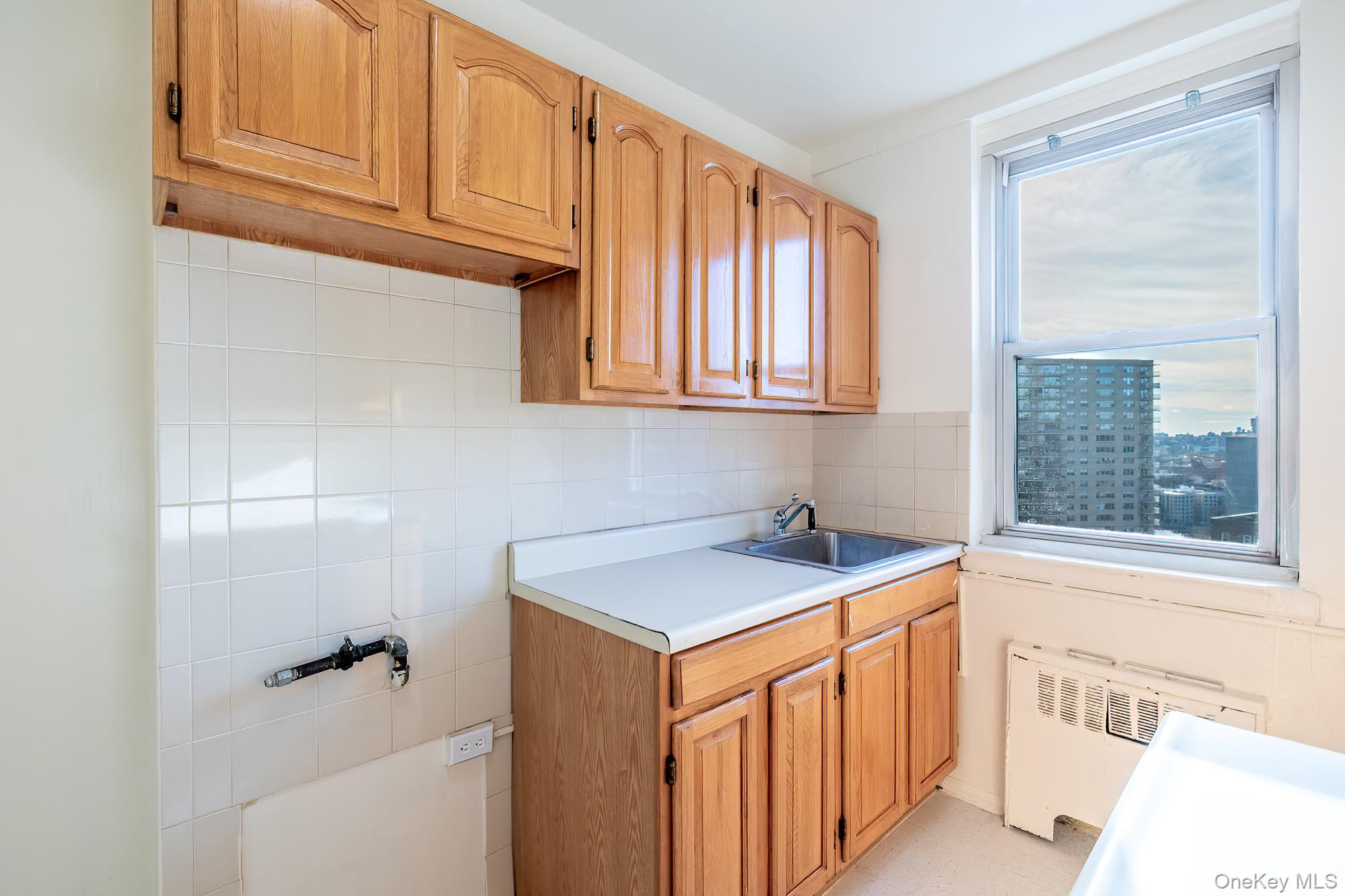 25 Knolls Crescent, Unit 8L Bronx, NY 10463 - Photo 5 of 21 Laundry area with radiator heating unit and tile walls