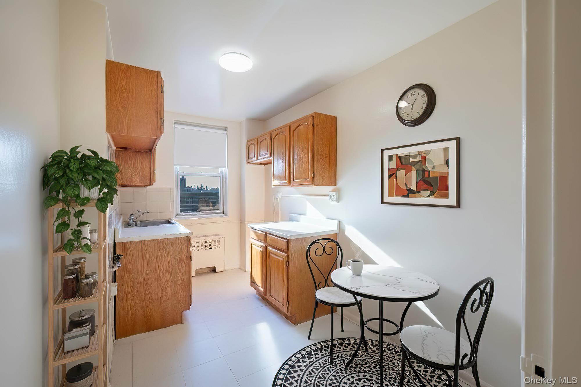 25 Knolls Crescent, Unit 8L Bronx, NY 10463 - Photo 7 of 21 Kitchen with light countertops, radiator heating unit, and tasteful backsplash