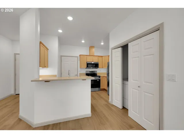 a open kitchen with cabinets stainless steel appliances and a window