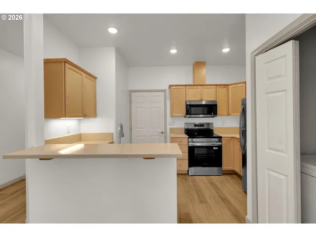 a kitchen with kitchen island a sink stainless steel appliances and cabinets