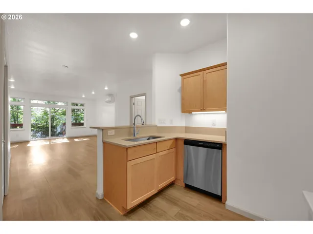 a kitchen with a sink cabinets and wooden floor