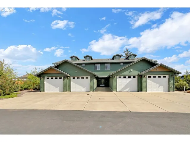 a view of a big house with a big yard and large trees
