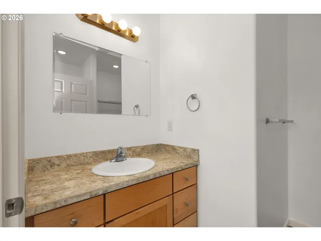 a bathroom with a sink vanity granite and a mirror
