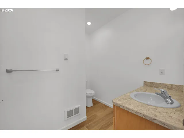 a bathroom with a granite countertop sink and toilet