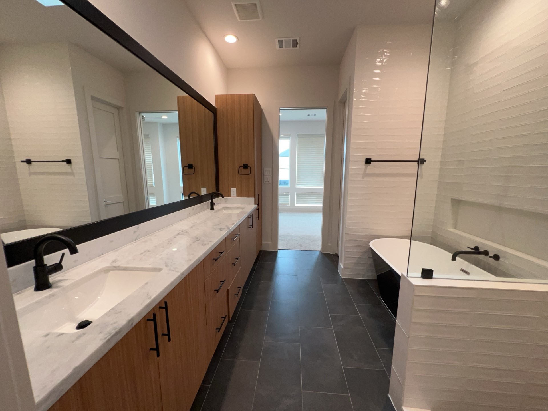 2414 Gray Street Houston, TX 77003 - Photo 8 of 14 a bathroom with a double vanity sink a mirror and a bathtub