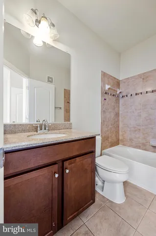 a bathroom with a granite countertop sink a toilet a mirror and shower