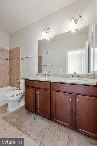 a bathroom with a granite countertop sink a toilet and a mirror