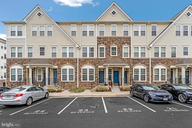 a couple of cars parked in front of a white house