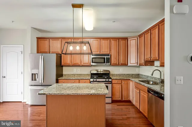 a kitchen with stainless steel appliances granite countertop a stove a sink dishwasher and a refrigerator