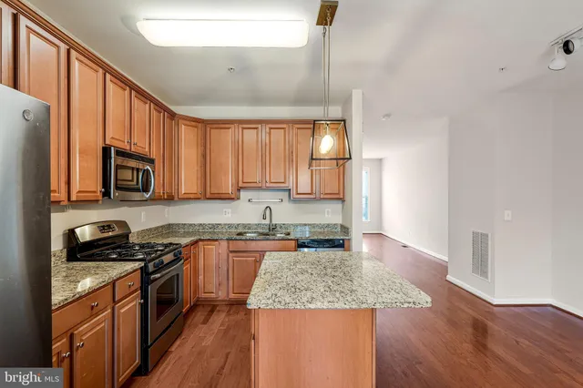 a kitchen with stainless steel appliances granite countertop a sink stove microwave and cabinets
