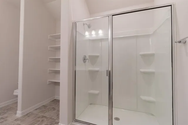 a bathroom with a glass shower door
