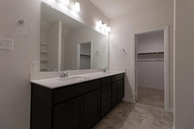 a bathroom with a double vanity sink and mirror